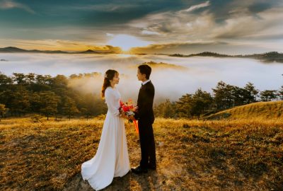 Couple Standing On Grass Field While Looking At Each Other